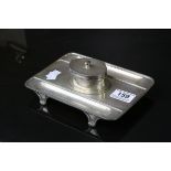 *Early 20th century silver inkstand of rectangular form raised on four scroll feet, two pen trays