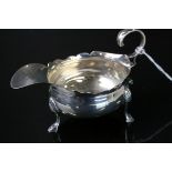 Edwardian silver milk jug raised on three hoof feet with shell shoulders, scroll handle with