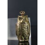 Antique brass sovereign holder in the form of an owl with glass eyes