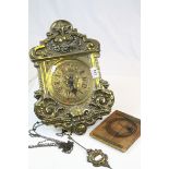 Antique brass fronted wall clock with classical scrolling decoration and griffin and mask