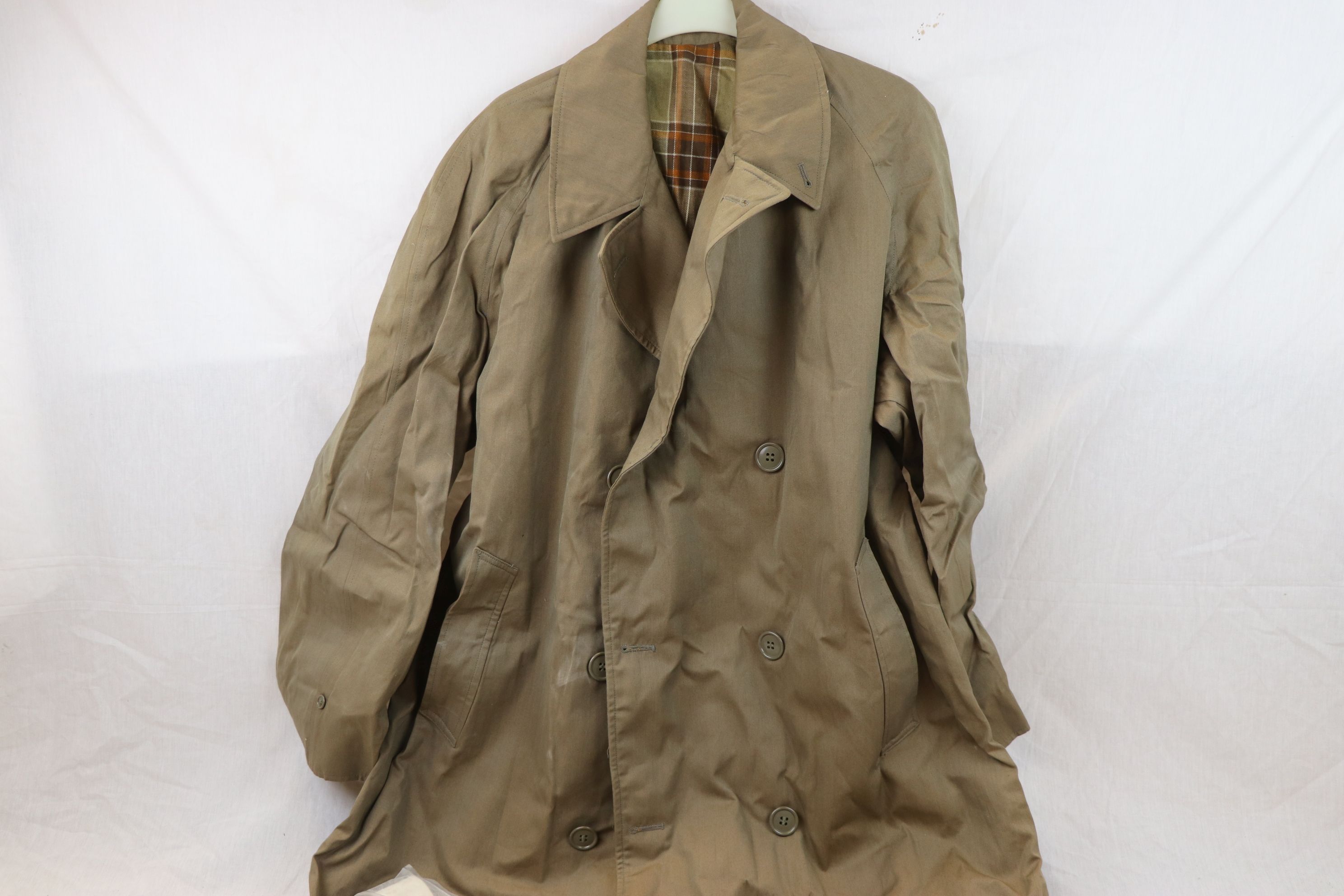 A Small Collection Of Military Clothing To Include A Demobilised Soldiers Raincoat Dated 1956 And