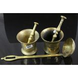 Two brass mortars with unassociated brass pestle, together with a large brass ladle (3)