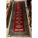 Two Matching Red Ground Runner Rugs with Geometric Patterns surrounding by a Panel, 257cms x 78cms