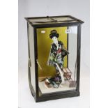 20th century figure of a geisha girl contained in a wooden glazed cabinet