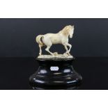 Antique carved ivory horse mounted on an oval plinth