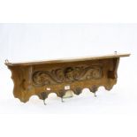 Golden Oak Hall Shelf with Coat Hooks, the back panel carved with a face mask and scrolls, 97cms