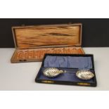 A cased set of twelve glass knife rests together with a pair of silver plated salts in the form of