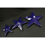 Set of three graduating, blue painted, metal star shaped wall plaques