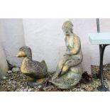 Composite stone garden ornament in the form of a seated nymph & a similar duck