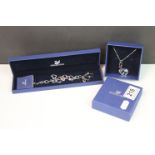 A boxed Swarovski charm bracelet together with a boxed Swarovski necklace.