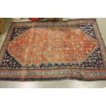 Middle Eastern Wool Red and Blue Ground Rug with decoration of stylised flowers within a border,