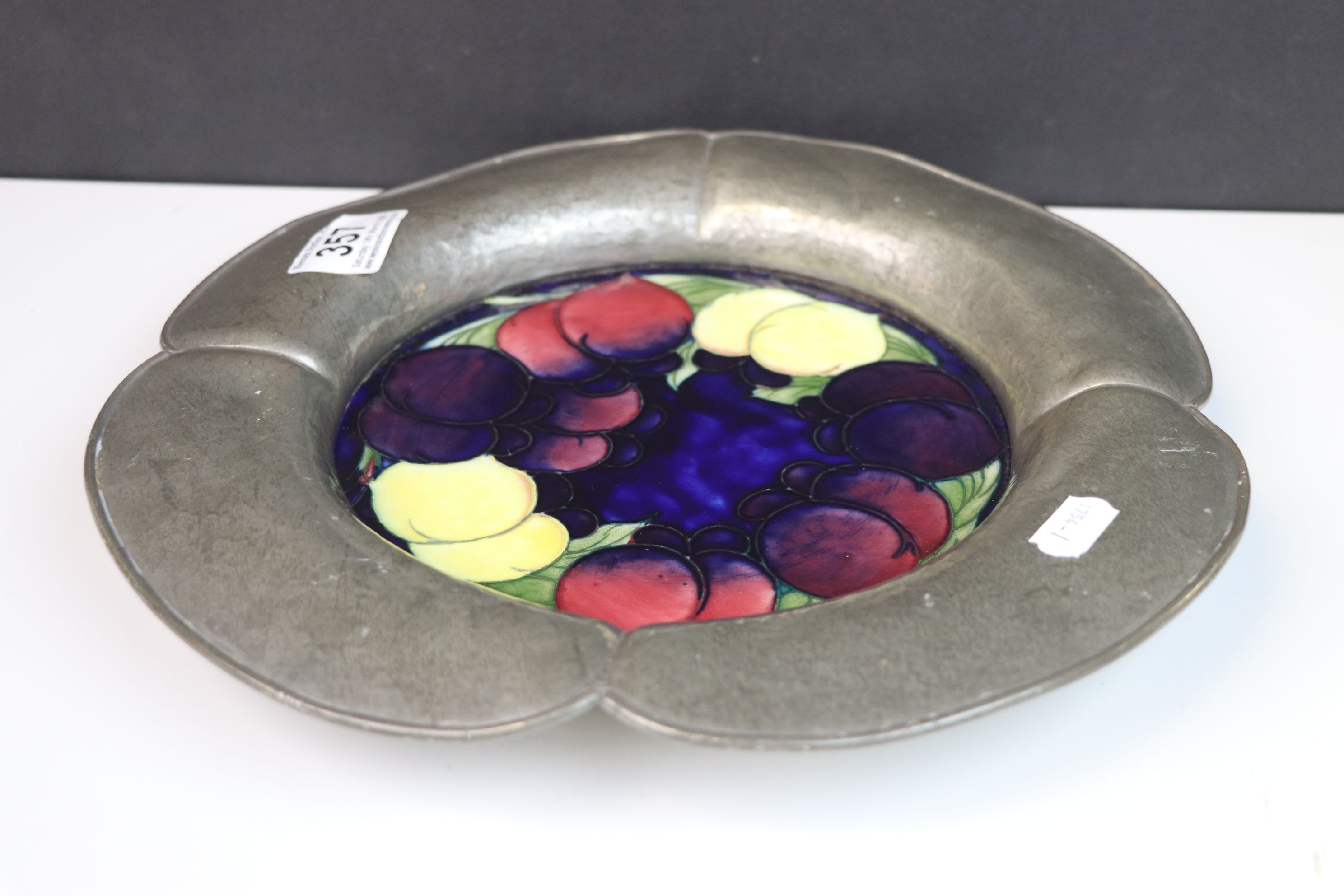 A Moorcroft wisteria pattern plaque set into an english made pewter surround.