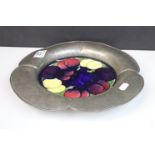 A Moorcroft wisteria pattern plaque set into an english made pewter surround.