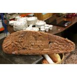 Profusely carved hardwood tribal panel, men in a crocodile shaped canoe with paddles surrounded by