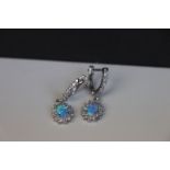 A pair of silver, cz and blue opal earrings