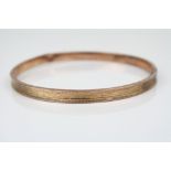 9ct rose gold slave bangle, bright cut repeating decoration, width approximately 5.5mm (af)