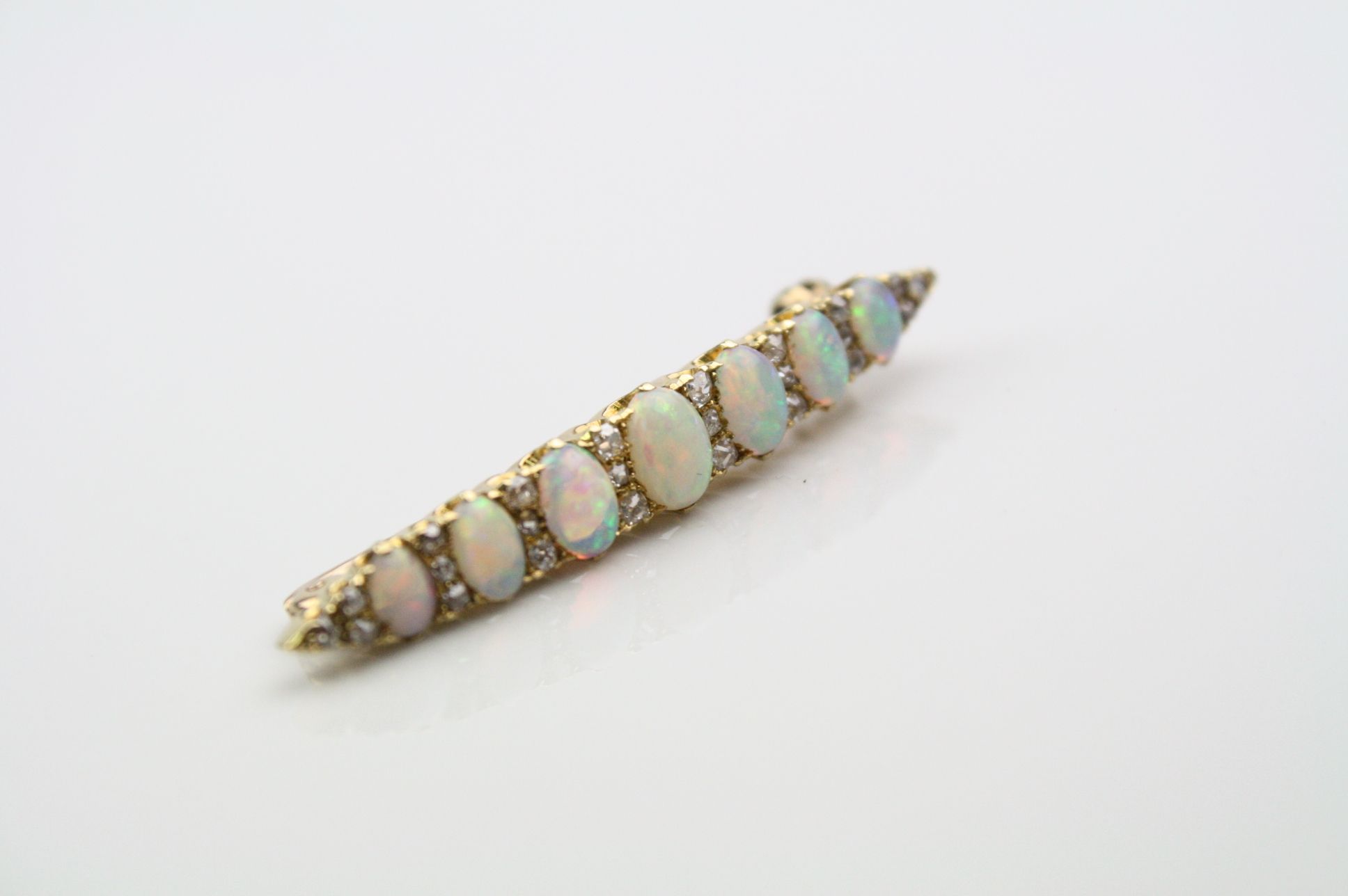 Opal and diamond yellow metal bar brooch, seven graduated precious white cabochon cut opals, - Image 4 of 4