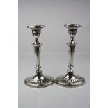 Pair of silver candlesticks, inverse bell shaped sconce to tapered faceted and knopped stem,