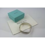 Tiffany & Co silver cushion bangle, stamped 925 T&Co 1837 to centre, width approximately 1.5cm, with