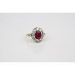Lead glass filled ruby and diamond 18ct yellow gold white gold set cluster ring, the centre oval