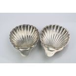 Pair of silver scallop shaped ash trays, each raised on three ball feet, makers The Alexander