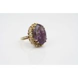 Amethyst 9ct yellow gold dress ring, the oval mixed cut amethyst measuring approximately 20mm x