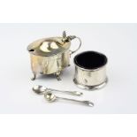 George V silver mustard pot of oval form raised on four scroll feet, stylised shell thumb piece,