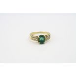 Emerald and diamond 18ct yellow gold ring, oval mixed cut emerald to centre measuring