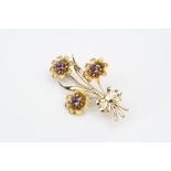 Amethyst 9ct yellow gold floral spray brooch, three round mixed cut amethyst forming the flower