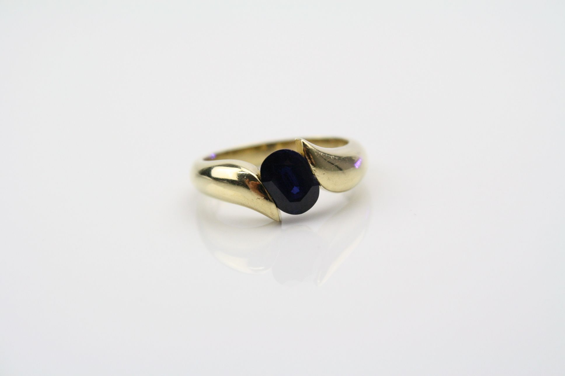 Sapphire yellow metal ring, the oval mixed cut blue sapphire measuring approximately 8mm x 5.5mm,