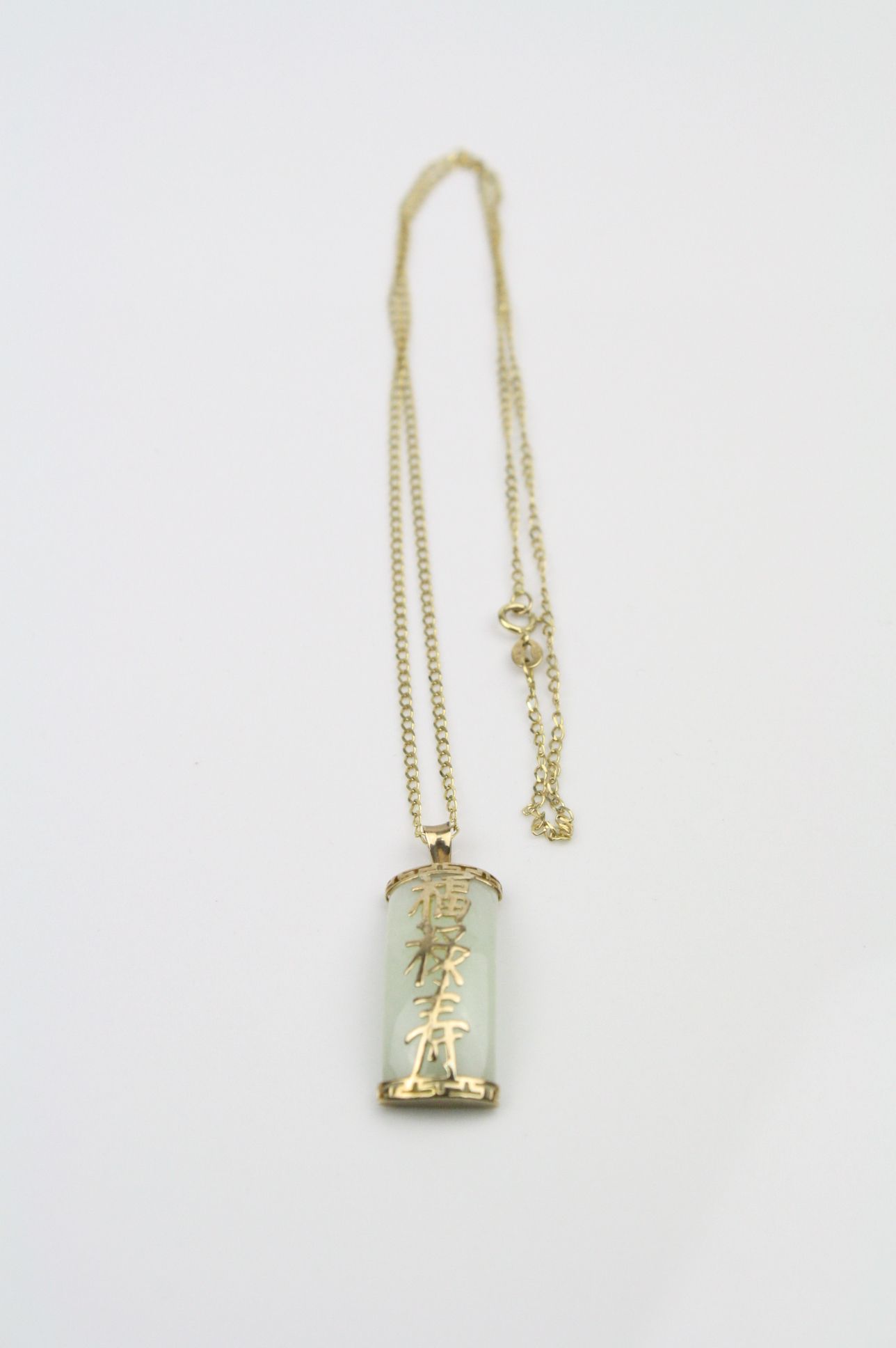 Jade 9ct yellow gold pendant necklace, the rectangular convex cabochon jade measuring