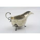 Silver milk jug, raised on three hoof feet, pie crust border, scroll handle with acanthus leaf