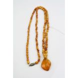 Butterscotch amber bead necklace, comprising 122 small amber oval beads with larger amber dropper,