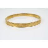 15ct yellow gold bangle, bright cut repeating decoration, width approximately 7mm, inner