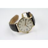 A vintage 9ct gold cased Omega Geneve Swiss made Gents wristwatch with date window to the three