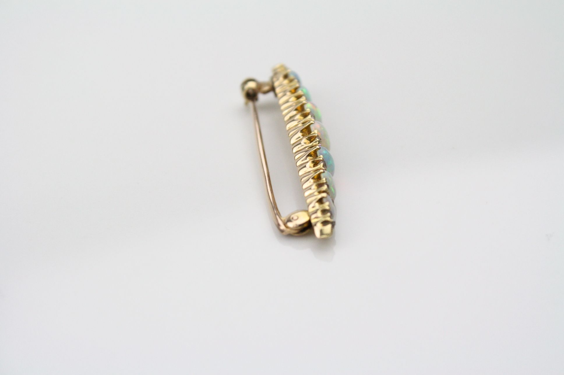 Opal and diamond yellow metal bar brooch, seven graduated precious white cabochon cut opals, - Image 2 of 4