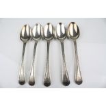 Five George III silver bead and thread pattern silver dessert spoons, crested terminals, makers John