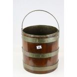 A Georgian style mahogany and brass bound coal barrel with a swing handle and liner. Diameter