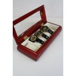 A collection of three skeleton dial wristwatches within a glass topped display box.