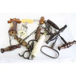 A collection of antique corkscrews and bottle openers together with a ceramic toilet pull handle.