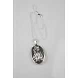 Silver locket on chain with embossed image of a cat with ruby eyes and emerald collar