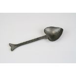 A hammered pewter spoon with heart shaped bowl and fin decoration, marked JIG to the verso.
