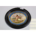 19th century Continetal Oval Porcelain Plaque painted with a scene of a Cherub surrounded by Flowers