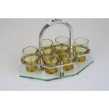 An Art Deco set of six shot glasses in a clear glass and plated stand.