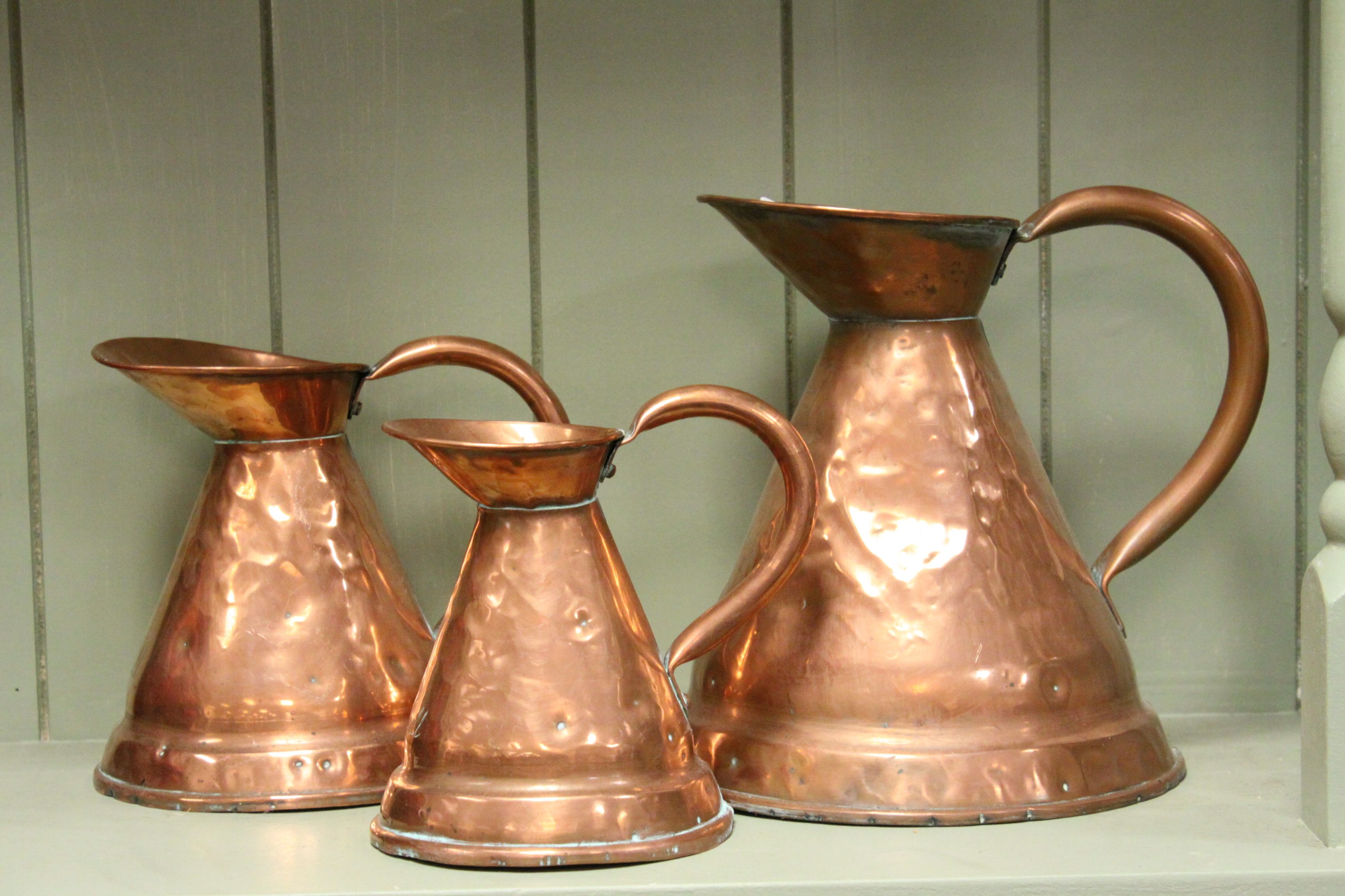 Three Antique Copper Graduating Measuring Jugs marked 1/2 Gall, 1/4 Gall and 1/8 Gall