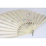 A antique oriental silk fan mounted to ivory with a floral and butterfly design to the front.