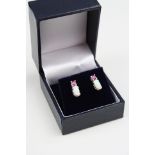 Pair of silver earrings set with rubies and opals