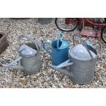 Three Vintage Watering Cans and a Fire Bucket
