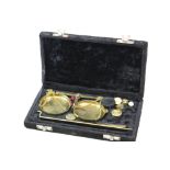A cased set of vintage brass balance scales with weights.