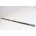 Early 20th century Swagger Stick, the white metal handle with embossed decoration of South East
